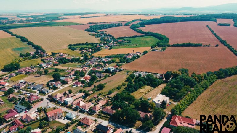 Légi felvétel a Csermányban található lakóterületekről, amelyeket kiterjedt mezők és zöldterületek vesznek körül.