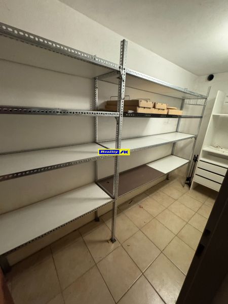 Tárolóhelyiség családi házban fém polcokkal és padlócsempével.