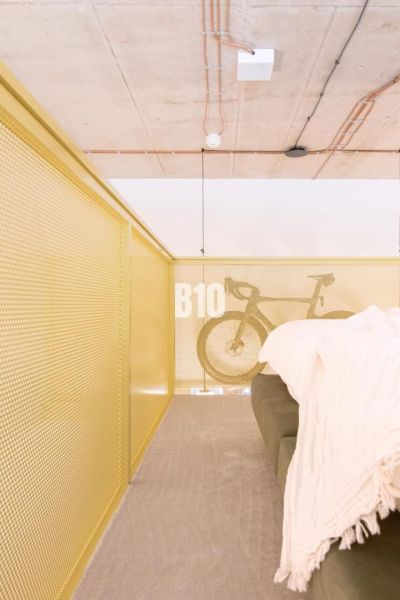 Loft tér egy kétszobás lakásban, kerékpárral és kanapéval a korlátnál.