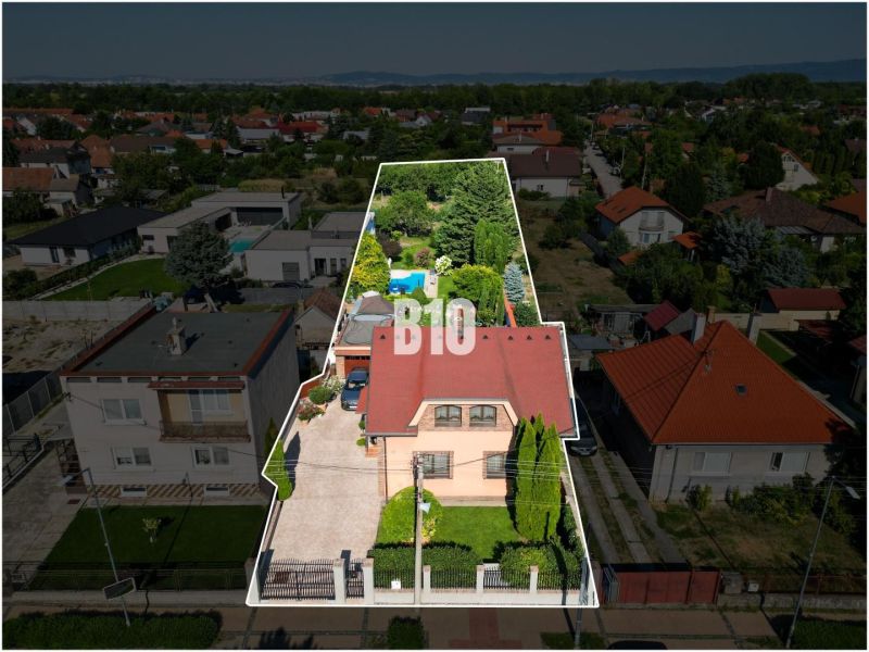 Családi ház a Malinovói Pozsonyi utcában, zölddel és szomszédos házakkal körülvéve.