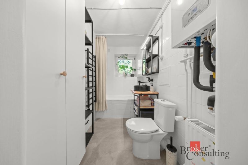 Fürdőszoba káddal, mosdóval és WC-vel egy 2 szobás lakásban, modern felszereléssel.