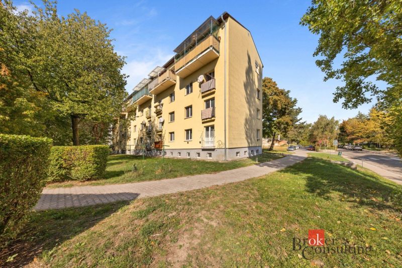 Társasház a Hubeného utcában, Pozsony-Rača városrészben, zöldövezet és út által körülvéve.