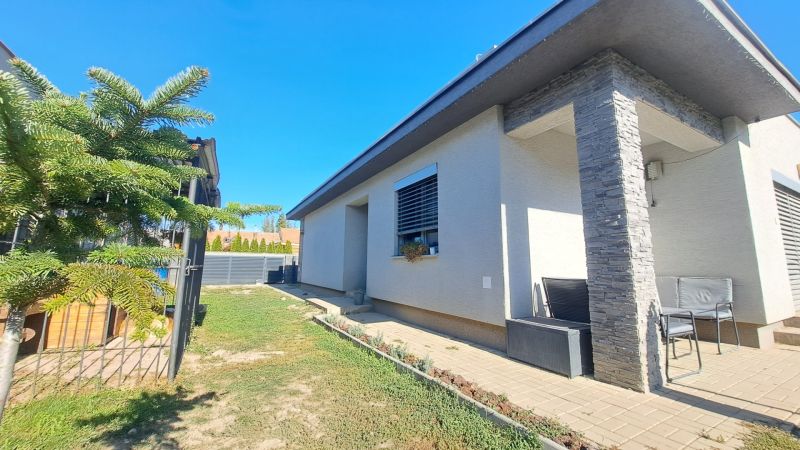 Családi ház Felsőszelibán terasszal, zölddel és fa dekorációval a burkolaton.