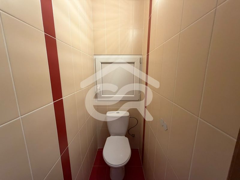 Fürdőszobai csempék egy háromszobás lakásban bézs és piros szín kombinációjával.